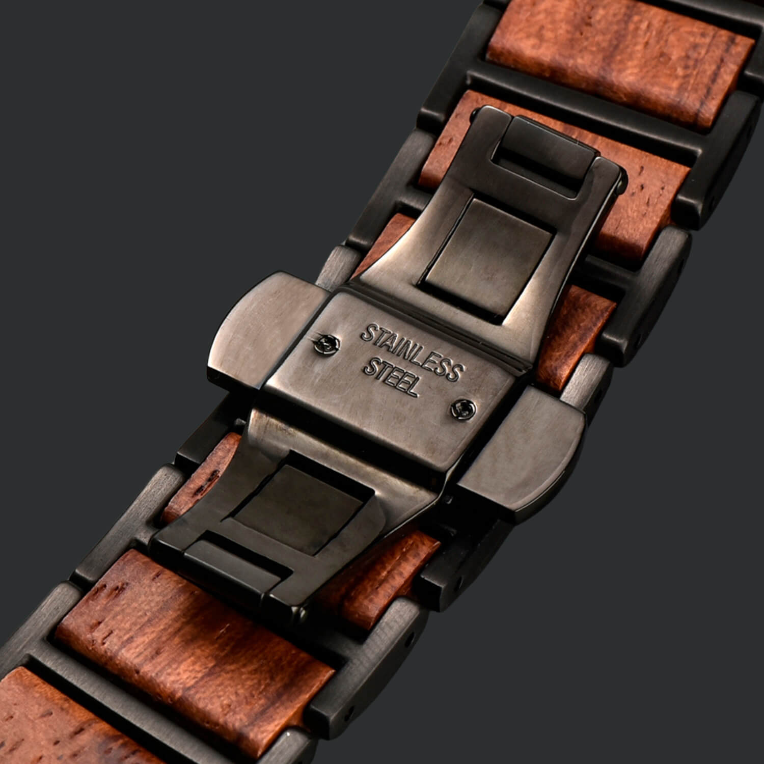 Close-up of a apple watch band with wooden accents and stainless steel butterfly clasp