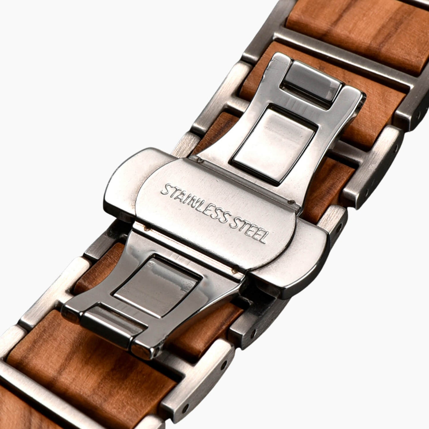 Close-up of an apple watch strap with wooden finish and metal butterfly clasp on a dark background